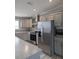 Modern kitchen with gray cabinets, stainless steel appliances, granite counters, and view of range hood at 15591 Charmwood Dr, Hudson, FL 34667