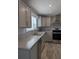 Modern kitchen with gray cabinets, stainless steel appliances, granite counters, and stainless steel sink at 15591 Charmwood Dr, Hudson, FL 34667