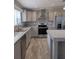 Modern kitchen with gray cabinets, stainless steel appliances, granite counters, and stainless steel sink at 15591 Charmwood Dr, Hudson, FL 34667