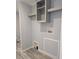 Practical laundry room with shelving and connections for a washer and dryer at 15591 Charmwood Dr, Hudson, FL 34667