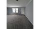 Spacious living room featuring plush carpeting, neutral paint, and windows for natural light at 15591 Charmwood Dr, Hudson, FL 34667