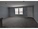 Living room features carpet, neutral paint, and white trim at 15591 Charmwood Dr, Hudson, FL 34667