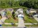 Beautiful aerial view of the residence with tropical landscaping, a pond, and surrounding homes at 1669 Ludington Ave, Wesley Chapel, FL 33543