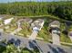Aerial view of a neighborhood showcasing a community pond and well-manicured lawns with palm tree landscaping at 1669 Ludington Ave, Wesley Chapel, FL 33543