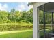An inviting backyard view features a serene pond and lush greenery, visible from a screened-in patio at 1669 Ludington Ave, Wesley Chapel, FL 33543
