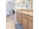 Bathroom featuring granite countertops, wood cabinets, and access to bedroom at 1669 Ludington Ave, Wesley Chapel, FL 33543