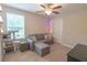 Comfortable bedroom with sofa, ottoman, and natural light from the window at 1669 Ludington Ave, Wesley Chapel, FL 33543