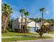 Two-story home featuring verdant lawn, mature palms, neutral stucco, and a teal garage door at 1669 Ludington Ave, Wesley Chapel, FL 33543