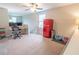 Cozy living room with two monitors on a desk and a vintage red refrigerator by the window at 1669 Ludington Ave, Wesley Chapel, FL 33543