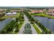 Community view with center road surrounded by trees, lakes, and homes at 16938 Scuba Crest St, Wimauma, FL 33598