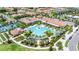 Aerial view of resort-style pool with palm trees, clubhouse, and sports courts at 16938 Scuba Crest St, Wimauma, FL 33598