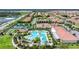 Aerial view showcasing a large pool, tennis courts, clubhouse, and beautiful landscaping at 16938 Scuba Crest St, Wimauma, FL 33598