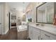 Bright bathroom featuring a soaking tub, elegant chandelier, dual vanities, and wood-look tile flooring at 16938 Scuba Crest St, Wimauma, FL 33598