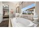 Relaxing bathroom features a soaking tub, a window view, and stylish decor at 16938 Scuba Crest St, Wimauma, FL 33598