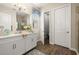 Bathroom featuring wood-look flooring, a large mirror, white vanity, and a view of the toilet room at 16938 Scuba Crest St, Wimauma, FL 33598