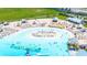 Aerial shot of a resort-style pool with beach-like entry and plenty of lounge chairs for sunbathing at 16938 Scuba Crest St, Wimauma, FL 33598