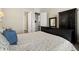Cozy bedroom featuring a bed with blue throw pillows, wood-look flooring, and neutral walls at 16938 Scuba Crest St, Wimauma, FL 33598