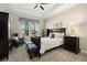 Well-lit bedroom featuring a tray ceiling, a sitting area, a bed, and carpet flooring at 16938 Scuba Crest St, Wimauma, FL 33598