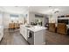 Open-concept kitchen features an island with a sink, connecting seamlessly to the dining and living areas at 16938 Scuba Crest St, Wimauma, FL 33598