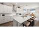 Modern kitchen boasts a large island with seating, sleek white cabinetry, and stainless steel appliances at 16938 Scuba Crest St, Wimauma, FL 33598