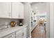 Modern kitchen with white cabinets, quartz countertops, and stainless appliances at 16938 Scuba Crest St, Wimauma, FL 33598