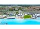 Panoramic view of the community lagoon featuring pristine turquoise waters, community buildings, and lush landscaping at 16938 Scuba Crest St, Wimauma, FL 33598