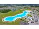 Wide aerial shot captures the community lagoon with its clear waters, sandy beaches, and recreational amenities at 16938 Scuba Crest St, Wimauma, FL 33598