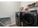 Modern laundry room equipped with front-load washer and dryer and wire shelving at 16938 Scuba Crest St, Wimauma, FL 33598