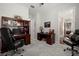 Spacious home office with two work stations, built-in shelving, and carpet flooring at 16938 Scuba Crest St, Wimauma, FL 33598