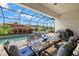 Covered patio with glass top dining table and seating at 16938 Scuba Crest St, Wimauma, FL 33598