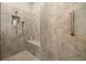 Tiled walk-in shower with built-in bench, recessed niche, and handheld shower head at 16938 Scuba Crest St, Wimauma, FL 33598