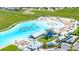 Overhead view of the community water park boasting slides, inflatable structures, and a sandy beach area at 16938 Scuba Crest St, Wimauma, FL 33598