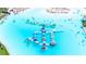 Aerial view of the neighborhood water park showcasing inflatable structures and water activities, perfect for families at 16938 Scuba Crest St, Wimauma, FL 33598