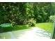 Secluded backyard with lush greenery, concrete patio, and whimsical hanging swing for outdoor enjoyment at 1855 Briland St, Tarpon Springs, FL 34689