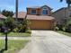 Inviting two-story home boasts a two car garage and vibrant landscaping at 1855 Briland St, Tarpon Springs, FL 34689