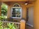 Charming front porch features neutral colors, a ceiling fan, and a sunny window at 1855 Briland St, Tarpon Springs, FL 34689