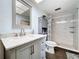 Bright bathroom features a shower and vanity with marble countertop at 1861 Royal Oak E Pl, Dunedin, FL 34698