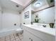 Bathroom with tiled floor, shower, white vanity, and decorative accents at 1861 Royal Oak E Pl, Dunedin, FL 34698