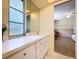 Bright bathroom vanity area with modern sink, white cabinets, and access to the bedroom at 1861 Royal Oak E Pl, Dunedin, FL 34698