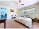 Cozy bedroom featuring neutral carpet, a ceiling fan and a window with outdoor views at 1861 Royal Oak E Pl, Dunedin, FL 34698