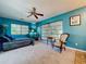 Well-lit bedroom with a ceiling fan, cozy chair, and sunny windows at 1861 Royal Oak E Pl, Dunedin, FL 34698