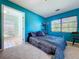 Comfortable bedroom featuring large windows and blue walls at 1861 Royal Oak E Pl, Dunedin, FL 34698