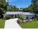 Charming single-story home with a well-manicured front yard and a winding driveway at 1861 Royal Oak E Pl, Dunedin, FL 34698
