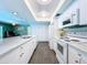 Bright kitchen with white cabinets, granite counters, stainless appliances and views to living room at 1861 Royal Oak E Pl, Dunedin, FL 34698