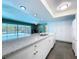 Kitchen featuring granite countertops, white cabinets, and access to dining and living area at 1861 Royal Oak E Pl, Dunedin, FL 34698