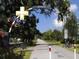 Scenic Dunedin pathway with overhead signage, lush greenery, and bike-friendly lanes at 1861 Royal Oak E Pl, Dunedin, FL 34698