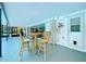 Covered patio with table and chairs overlooking a screened pool and lush backyard at 1861 Royal Oak E Pl, Dunedin, FL 34698