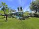 Screened-in pool area surrounded by lush landscaping, providing a private outdoor oasis at 1861 Royal Oak E Pl, Dunedin, FL 34698