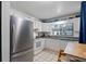 Well-lit kitchen with white cabinets, white appliances, granite countertops, and a stainless steel fridge at 1881 N Hercules Ave # 1501, Clearwater, FL 33765