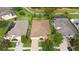 Aerial view of the home featuring a well-manicured lawn and brick-paved driveway at 19418 Butterwood Ln, Lutz, FL 33558